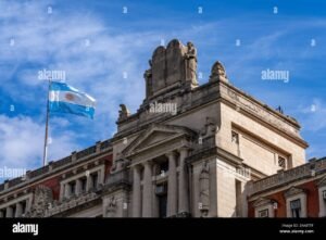 Cuánto está el IUS para trámites legales en Argentina 41 edificio judicial con bandera argentina ondeando