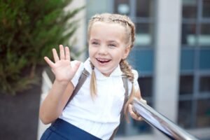 estudiantes sonrientes entrando a escuela primaria