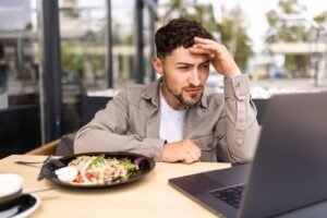 persona frustrada frente a computadora bancaria