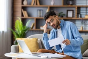 Cómo puedo consultar cuántas cuotas me quedan del préstamo de ANSES 45 persona revisando documentos financieros en casa